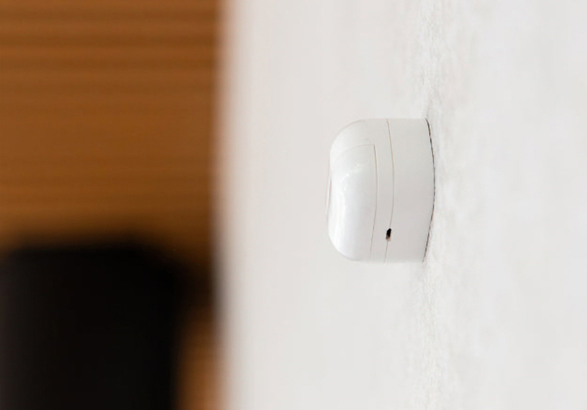 Shelly BLU Motion sensor mounted on a wall, seen side-on