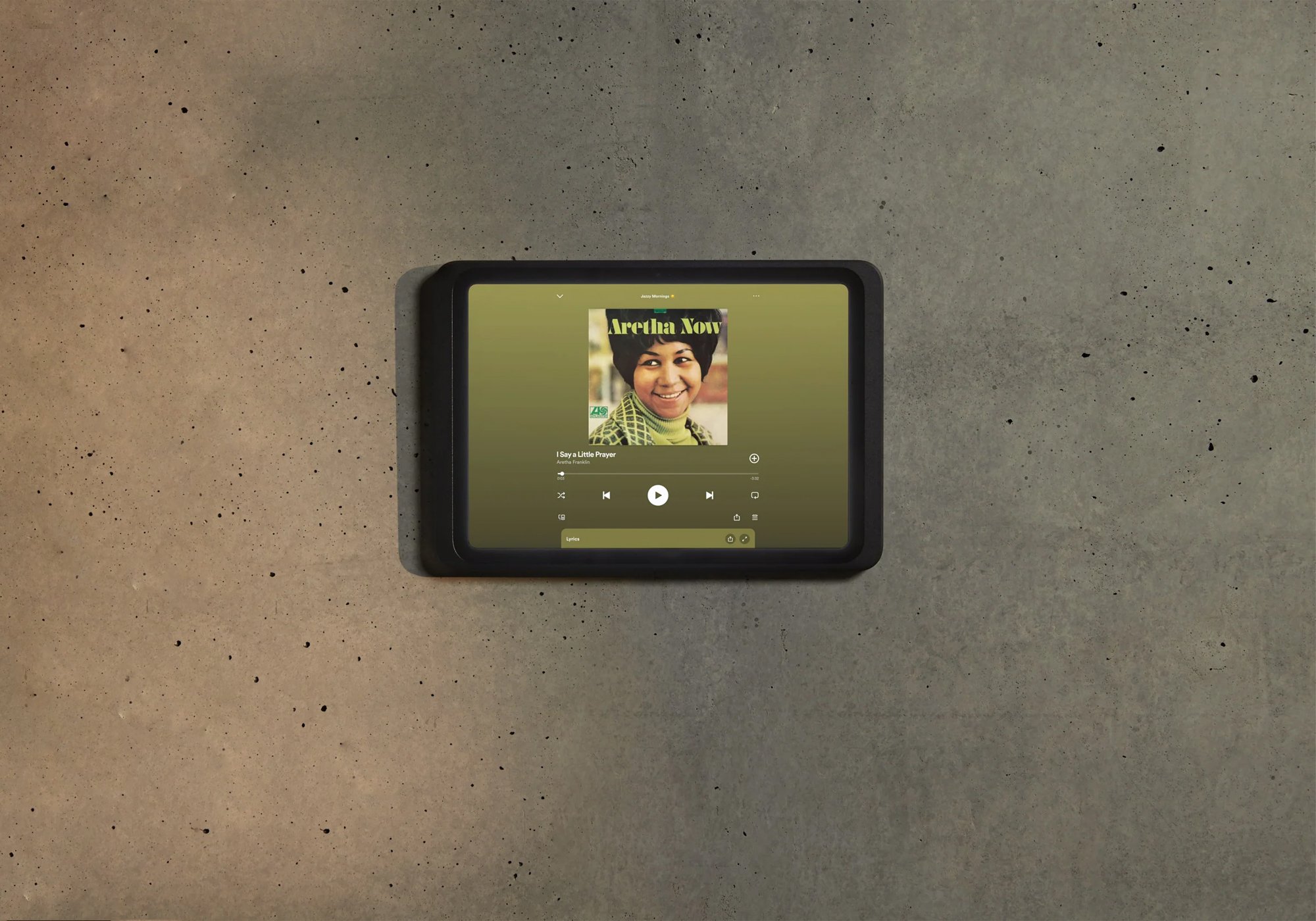 Displine Dame Wall 2.0 in black holding an iPad in landscape on a concrete wall, playing music