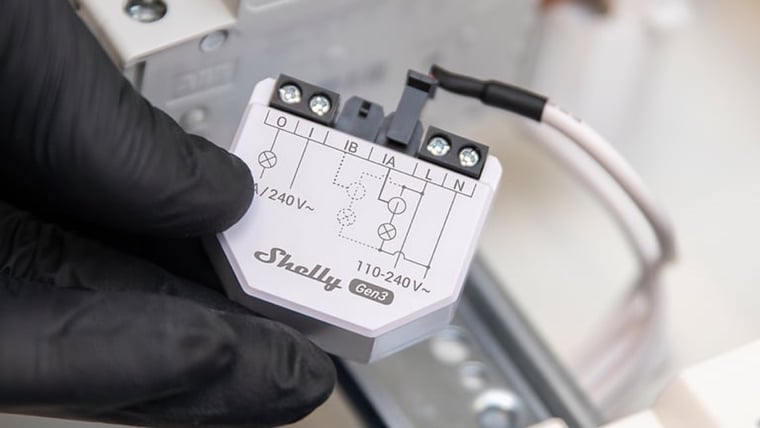 Shelly EM Gen3 Energy Meter being fitted to a DIN rail in a switchboard