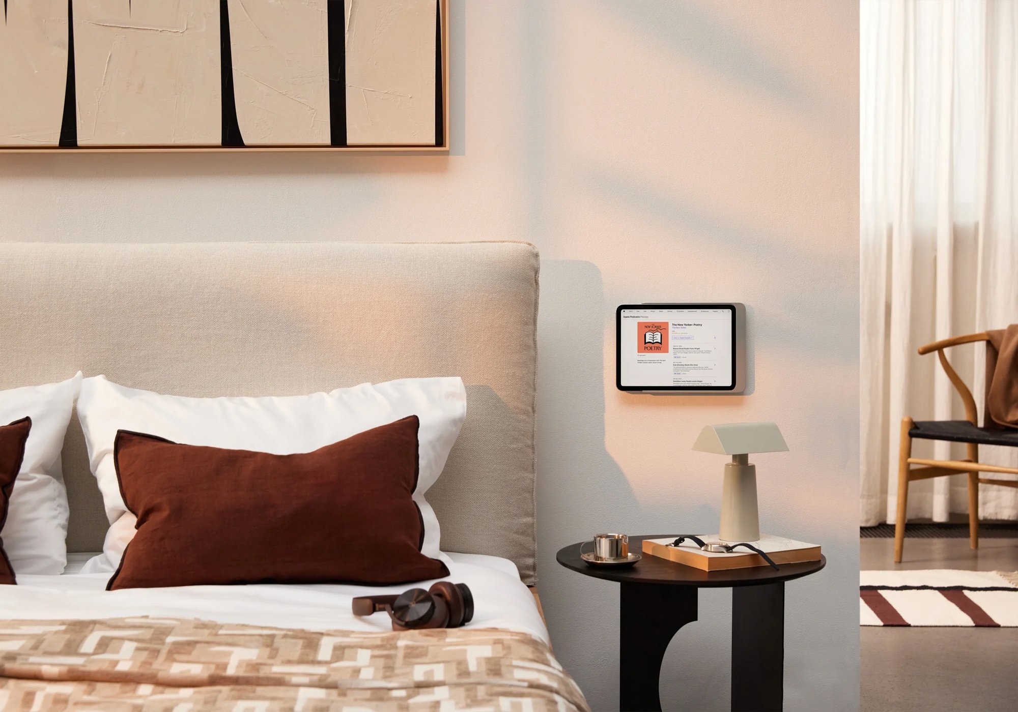 Displine Dame Wall Home 2.0 in rose gold holding an iPad on a bedroom wall beside a bed