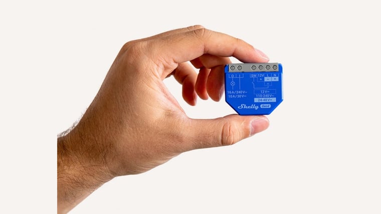 Shelly 1 Gen4 Smart Relay held between finger and thumb