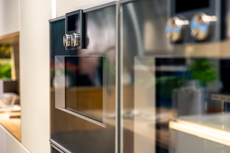 Two built-in stainless steel wall ovens in a kitchen, close up on the control dials